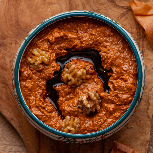 Muhammara - Roasted red peppers paste mixed with walnuts served with crispy bread.