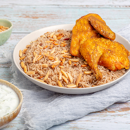 Middle Eastern Rice With Chicken - Rice Mixed With Minced Beef, Spices, Topped With Nuts, Served With Chicken And Cucumber Yogurt Salad