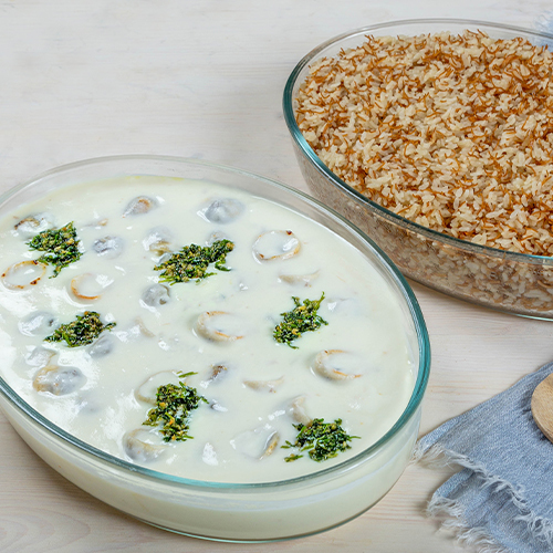 Shish Barak cathring - Meat dumplings cooked with yogurt sauce, coriander and garlic served with vermicelli rice.