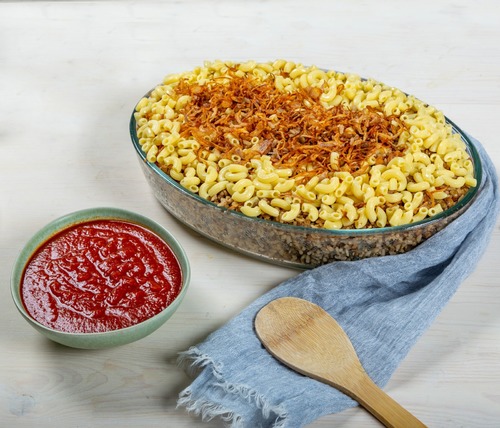 Koshari Umm Tariq Gathering - Koshari cooked in Umm Tariq’s special way, topped with macaroni and fried onions served with a special tomato sauce, serves 6 people.