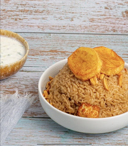 Cauliflower Maqluba Chicken - Rice cooked with cauliflower , mix of vegetables and chicken breast cubes garnished in nuts served with cucumber yogurt salad.