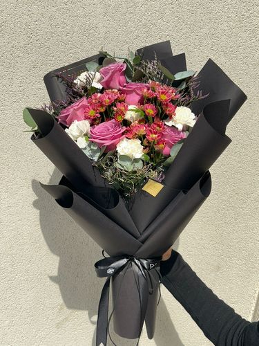 Purple bloom boquet - باقة ورد راقية بتغليف أسود فاخر
تتكون من تنسيق أنيق يجمع بين الورود الوردية الجذابة، وزهور الكريزنتيم الوردية، مع لمسات من الزهور البيضاء الناعمة وأوراق الأوكالبتوس الطبيعية.
تُغلف الباقة بورق أسود فاخر يعكس الفخامة والرقي، ومزينة بشريطة ساتان سوداء تضيف لمسة كلاسيكية فاخرة. 
تُعد هذه الباقة خيارًا مثالياً للتقديم في المناسبات الراقية، التهاني الخاصة، أو كهديّة تعبّر عن الذوق الرفيع والمشاعر الراقية.