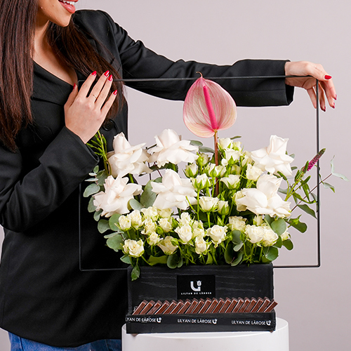 Starry Wonders - A black wooden basket with metal handle contains baby roses, roses, anthurium, veronica gaya, and eucalyptus with Belgian chocolates. Height: 52cm – Width: 54cm