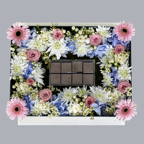 Cannes choco II - Cannes choco II contains gerbera flower and white, blue and pink roses and Belgian chocolates. Width: 40 cm x 30 cm    Height: 13 cm