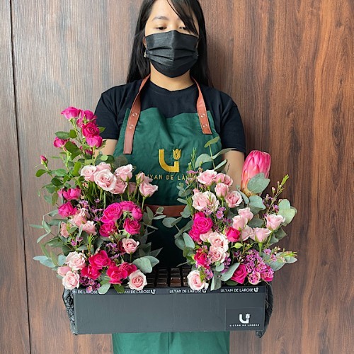 Center Piece - This black wooden rectangle contains variety of baby roses, wax flowers, queen protea and eucalyptus with Belgian chocolates. Height: 47cm – Width: 58cm