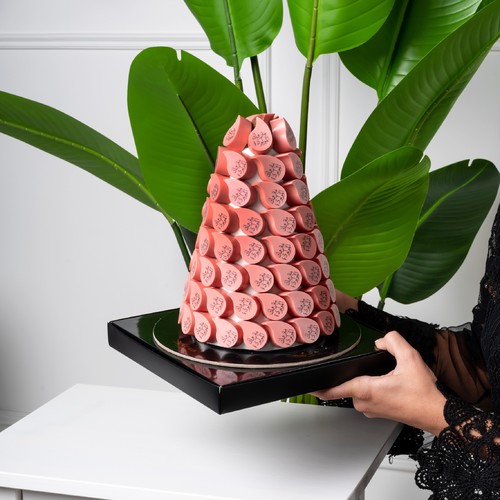 PINK CHOCOLATE TOWER - Chocolate pyramid Contains a kilo of chocolate Of the two flavors, pistachio and haselnut Writing of your choice in Arabic or English Please write it in the notes .