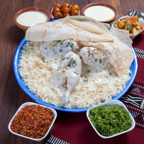 Mansaf Chicken Tray - Basmati rice with Chicken prepared with Jamid, nuts and hasho served with Mansaf broth, red mabog, green mabog, Agar and Luqaimat