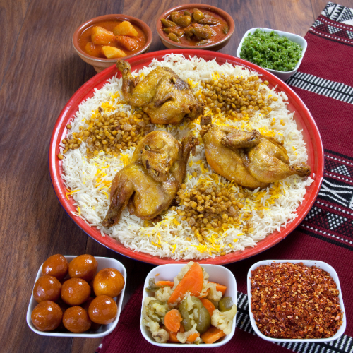 Chicken Machboos Tray - Basmati rice with  chicken and  filling served with broth, red maabouj, green maabouj, agar and luqaimat