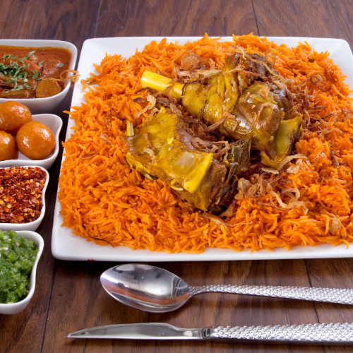 ِArabic Meat Kabsa - Basmati rice with tomato sauce, spices, and arabian meat chops with hasho served with broth, red mabog, green mabog and luqaimat.