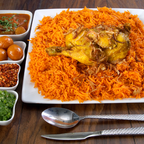 Chicken Kabsa - Basmati rice with  chicken tomato sauce, spices, chicken chops served with broth, red maabouj, green maabouj and luqaimat