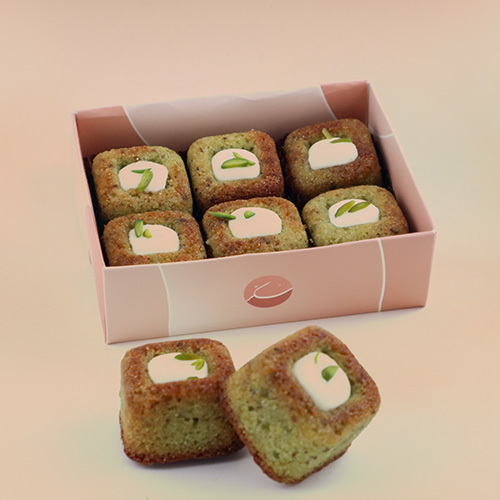 Mini Basbousa - Pieces of
delicious Basbousa covered with  cream  and pistachios with a special touch of Sukkar. 6 PCS