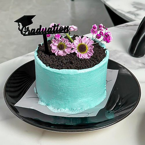 Mini Vase Blue cake - n elegant mini cake crafted in the style of a delicate flower vase. Layers of moist red velvet cake are filled with luscious strawberry compote and frosted with silky cream cheese. Topped with a fresh, regal purple gerbera daisy for a striking floral touch. A celebration of flavor and floral elegance. Enough for share with 2 personSize :Height 7cm Width 9.5 cm