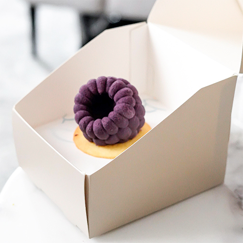 Berry Noir - A cake shaped like a berry, with layers of red velvet and berry cream, filled with blueberry, coated in white chocolate with a delightful crunch.