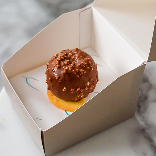 Nuttie Bliss - A chocolate cake with layers of chocolate Bavarian cream and milk chocolate ganache with crushed almonds, coated in chocolate almond glaze.