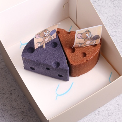 Tom & Jerry Chocolate Caramel Cheesecake -  Berry Cheesecake - A playful mix of indulgence – smooth chocolate cheesecake with a rich caramel swirl, layered over a crunchy biscuit base and filled with soft, moist chocolate richness. The finale comes with a crackling white chocolate crunch coat, giving every bite a perfect balance of creamy, gooey, and crunchy textures. A cheesecake that’s as mischievous and irresistible&nbsp;as&nbsp;Tom&nbsp;&&nbsp;Jerry!  
                                        A cheeky berry chase of flavors – rich berry cheesecake filling swirled with a juicy berry compote for a sweet–tangy surprise. At the base, a buttery biscuit layer adds a crunchy bite, while the whole creation is wrapped in a crisp white chocolate shell with extra crunch. A fun mix of creamy, juicy, and crunchy textures that’s as playful as Tom & Jerry’s&nbsp;adventures!