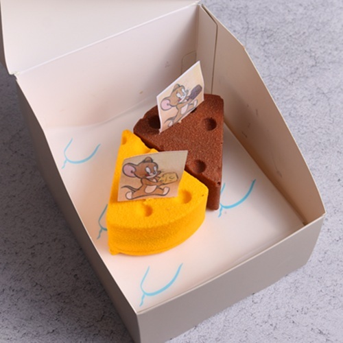 Tom & Jerry Mango Strawberry Cheesecake   -   Chocolate Caramel Cheesecake - A playful fruity indulgence layered with creamy mango cheesecake filled with a velvety mango center, resting on a soft vanilla sponge base. Hidden inside, a bright strawberry layer adds a juicy burst of flavor. The whole creation is coated in a crisp white chocolate shell, giving a fun contrast of crackling crunch outside and smooth cheesecake inside. A dessert full of creamy, soft, and crunchy textures – just like Tom & Jerry, always chasing and surprising!&nbsp; 
 A playful mix of indulgence – smooth chocolate cheesecake with a rich caramel swirl, layered over a crunchy biscuit base and filled with soft, moist chocolate richness. The finale comes with a crackling white chocolate crunch coat, giving every bite a perfect balance of creamy, gooey, and crunchy textures. A cheesecake that’s as mischievous and irresistible&nbsp;as&nbsp;Tom&nbsp;&&nbsp;Jerry!