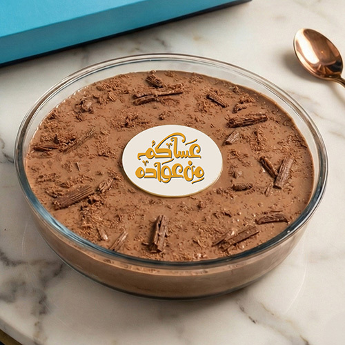 Eid Flake - A rich, indulgent dessert featuring layers of creamy Flake mousse and fudgy chocolate brownie cake, generously topped with delicate Flake chocolate slices, served beautifully in a clear ceramic bowl.