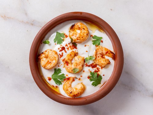 fatteh shrimp - grilled bread with chickpeas and yogurt topped with shrimps mixed arminian spices and nuts