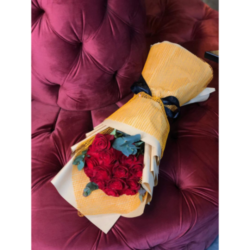 Licata - hand bouquet contains red roses and green leaves with beige and orange wrapping Height 40cm width 18cm