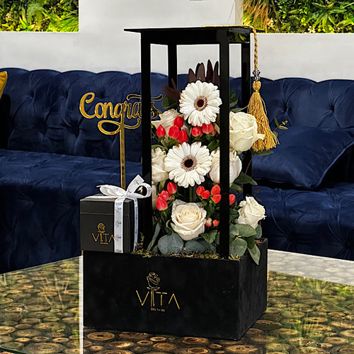 Covno - Black box contains white gerbera, safari sunset, green leaves ,orange baby roses, graduation cap , congrats gold stick with box of chocolate. Height: 55 Width: 35