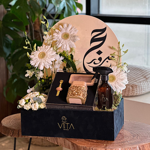 The Second - Black box contains white baby roses, dried fruit, white gerbera with spray perfume with package containing mubkhar, charcoal handle and box for bakhour. Height: 65 Width: 40