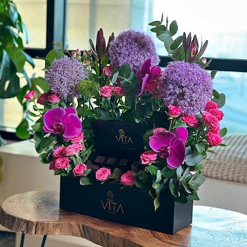 Cresh - A black box that contains oleum purple, green leaves, orchid purple and safari, dianthus, baby roses and a box of chocolate. Height: 25 Width: 35