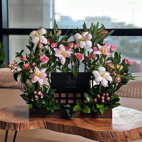 Vita Dei Fiori - arman - A wooden tray that contains pink, white tulip, hypericum pink baby roses pink astomeriya pink ruscus leaves and box of chocolates. Height: 35 Width: 30