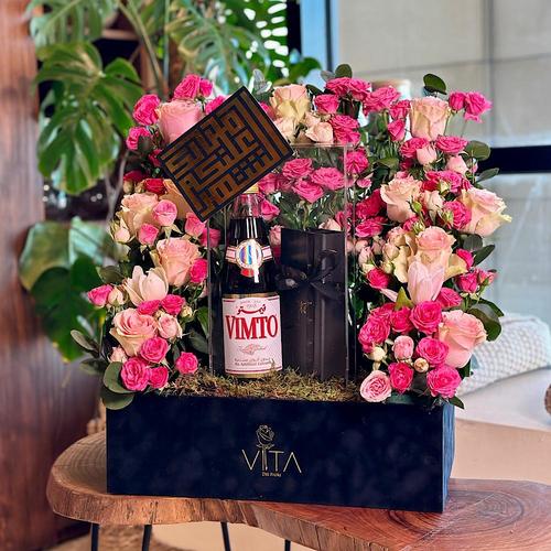 Vele - A black box that contains pink roses, fusia pink baby roses, green leaves with Vimto and a box of chocolates. Height: 60 Width: 40