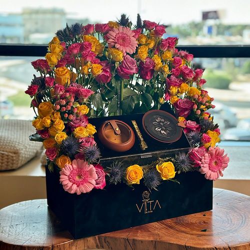 Stoinis - A black box contains roses, baby roses, hypericum, gerbera, eryngium and eucalyptus with acrylic box filled with mubkhar, charcoal and an empty bokhour storage box. 
 Height: 50 Width: 40