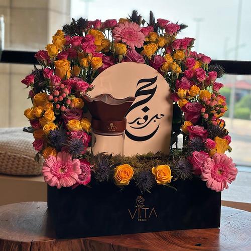 Melo - A black box contains roses and baby roses, hypericum, gerbera, eryngium and eucalyptus with acrylic Haj stick & with mubkhar with an empty bokhour and home fragrance. Height: 50 Width: 40