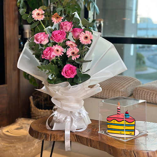 Angellica - Hand bouquet contains pink grabera pink roses with white wrapping with cake Height: 60  Width: 15