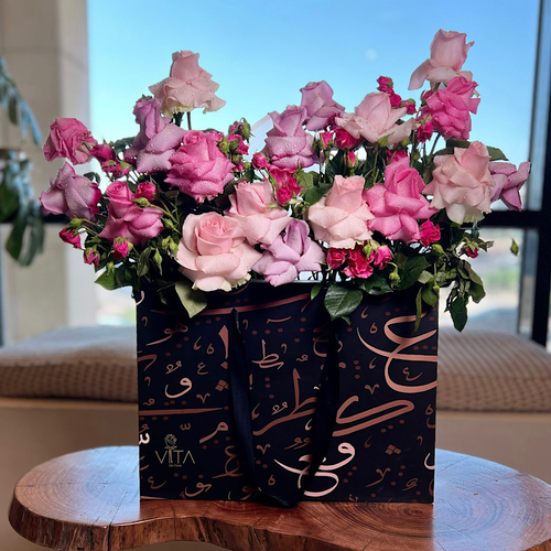 Wellness - Black box contains pink,fucia,purple roses with green leaves Height: 5 5 Width: 40