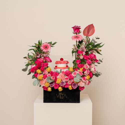 Marble - A black box contains pink anthurium, green leaves, and baby roses with a cake. Height: 25 Width: 45