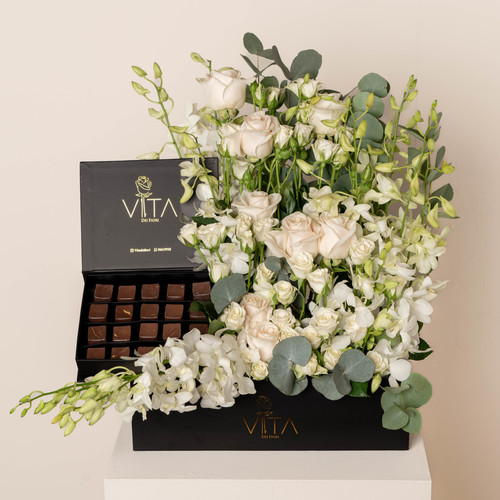 Uzu - A black box contains white roses, white baby orchid and green leaves with a box of chocolates. Height: 55 Width: 40