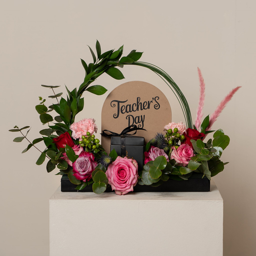 gol - black tray contains pink, purple roses with green leaves and box of chocolate with teachers' day stand Height: 35  Width: 35