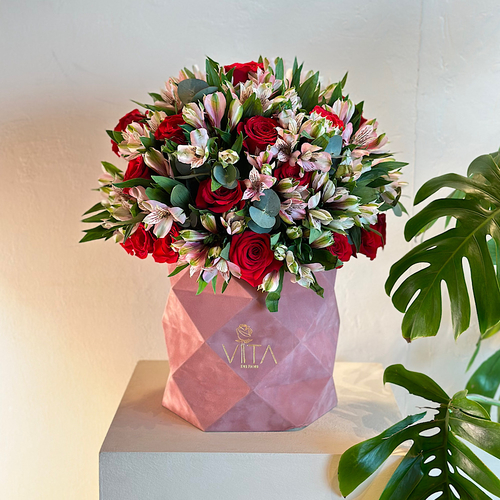 Dazzling - A pink box containing red roses and pink alstroemerias with green leaves arranged beautifully. Height: 60  Width: 25