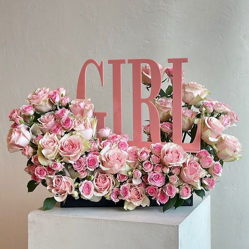 Girly - A .tray elegantly filled with pink roses and baby roses with girl acrylic topper Height: 60 Width: 20