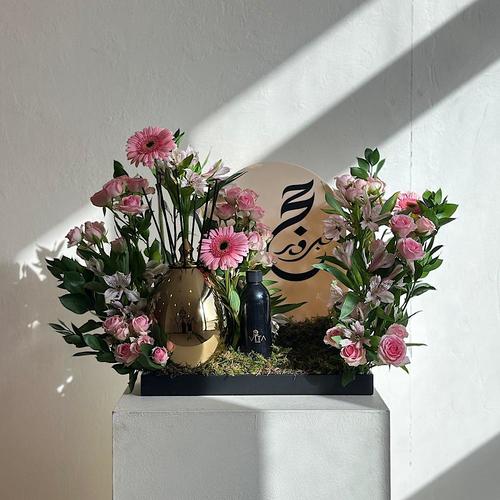 Groot - A tray elegantly filled with baby roses, gerbera and green leaves with a 250 ml diffuser and acrylic hajj topper. Height: 50 Width: 20