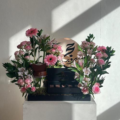 Bihor - A tray elegantly filled with baby roses, gerbera and green leaves with mubkhar with an empty space down to place the bakour, with chocolates and acrylic hajj topper. Height: 40 Width: 20