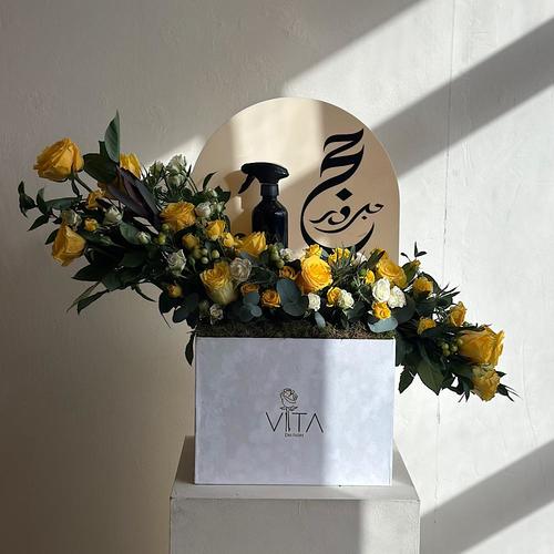 holy - A box filled with yellow roses, safari, baby rose white, baby rose yellow, hypericum green,eryngium,green leaves whit a home fragrance spray and acrylic hajj topper. Height: 70 Width: 40