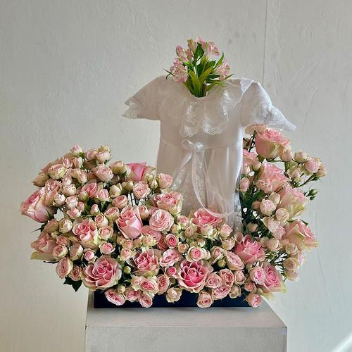 Marino - A tray elegantly arranged with pink roses and baby roses. Comes with a white dress for a newborn baby. Height: 60 Width: 20