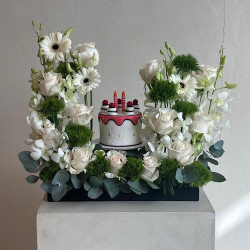 Vita Dei Fiori - ميكا - صينية تحتوي على زهور الجوري، الجيربيرا والأوركيد البيضاء مع الديانثوس وأوراق الأوكالبتوس. تأتي مع كيكة. 
 ارتفاع : ٥٥    عرض : ٢٠