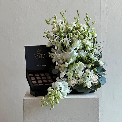 Uzu - A tray elegantly filled with white roses, white baby orchid and green leaves with a box of chocolates. Height: 45 Width:  30