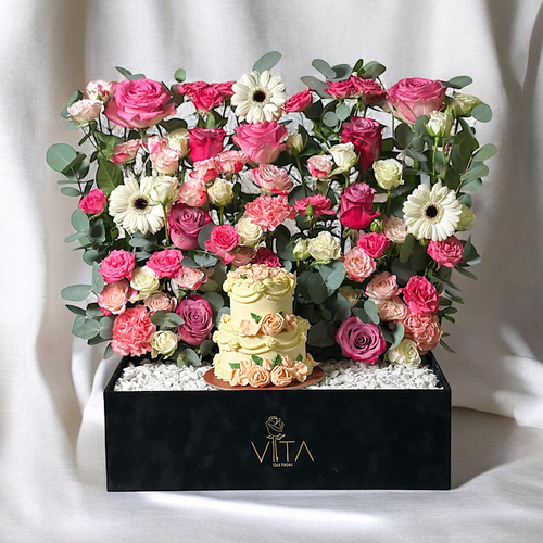 York - A box that contains roses, baby roses, gerberas, carnations and eucalyptus leaves along with a cake. Height: 50 Width: 40