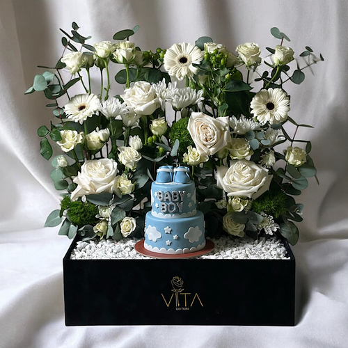 Aura - A black box contains white roses, gerberas, white and baby roses white chrysanthemums white hypericum , green stick and eucalyptus leaves. comes with a two layered baby boy cake. Height: 50 Width: 40