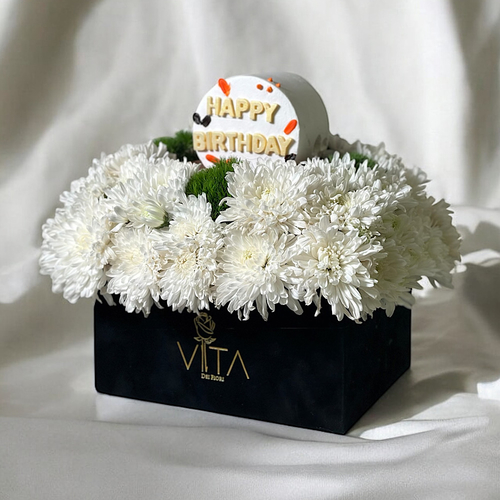Lavish - A black box containing white chrysanthemums and green leaves, arranged beautifully with a cake. Height: 30 Width: 20