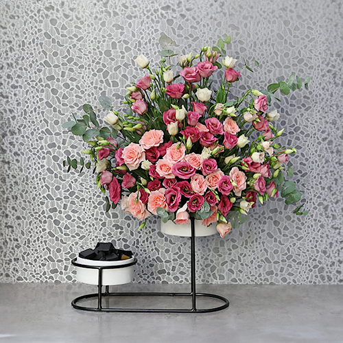 Everly Mix - Height: 70 cm
Width: 50 cm
 A stand contains lisianthus flowers and baby roses with chocolates.