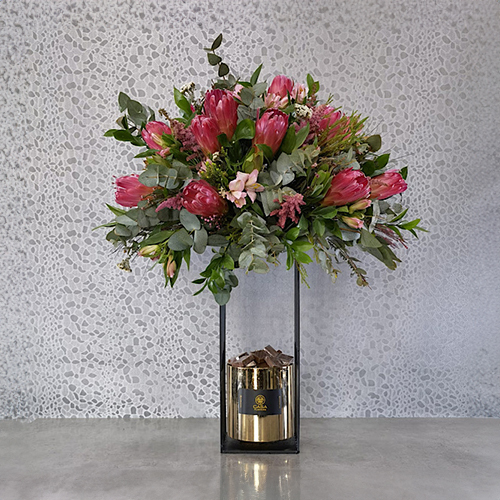 Oblation - Height: 80 cm
Width: 70 cm
 A stand contains protea flowers and safari with chocolates.