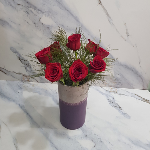 Roses In Purple Vase 527 - This beautiful purple vase is filled with 8 roses, creating a stunning centerpiece for any room. The greenery of the tree adds a touch of freshness to the arrangement. height 35 cm  width 25 cm