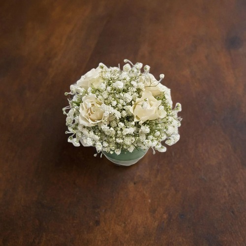 center piece white gypsophilia and baby rose white 1908 - This elegant center piece features a round vase filled with delicate baby's breath flowers, also known as white gypsophilia and baby rose white. Standing at a height of 15 cm and with a width of 10 cm, this arrangement adds a touch of sophistication and charm to any space.